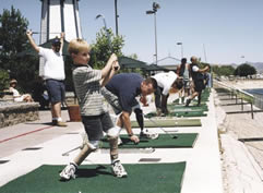 Niño jugando al golf usando piernas protésicas
