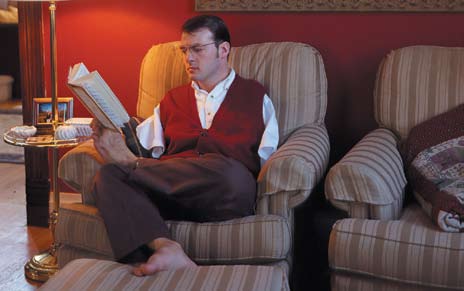 Upper limb amputee reading a book with feet.