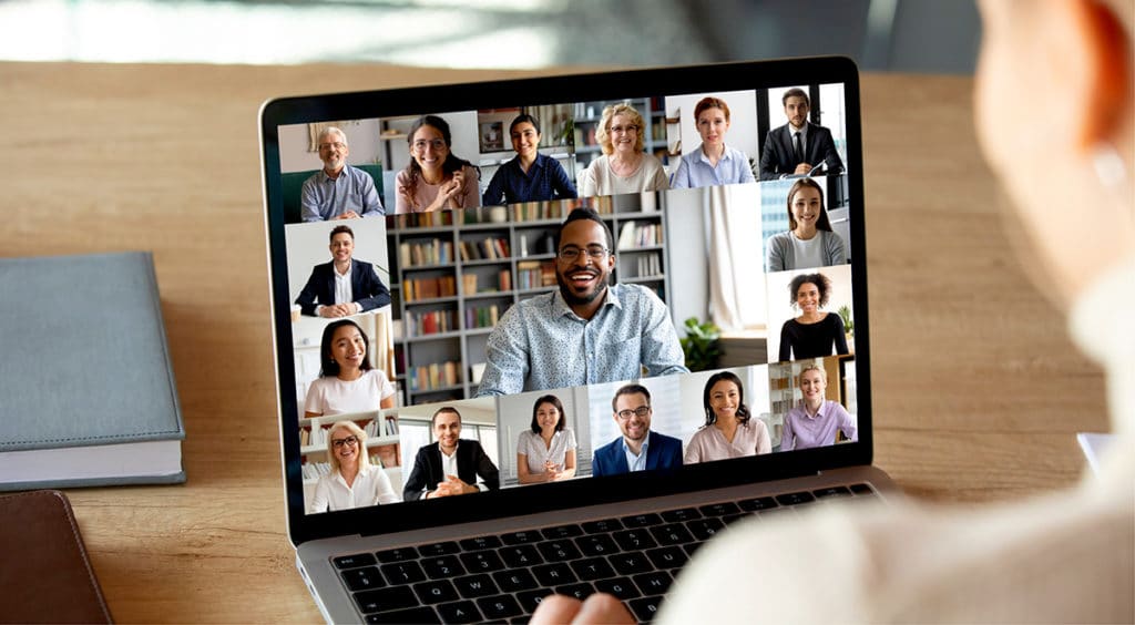 Laptop screen showing faces on online meeting